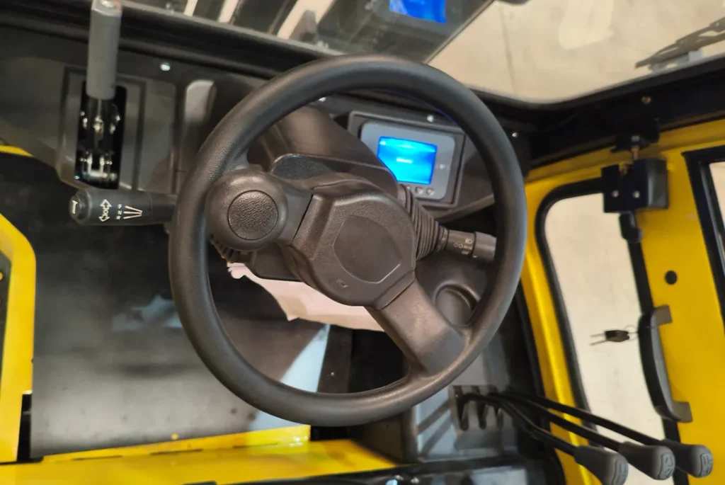 Steering wheel and dashboard of yellow electric forklift