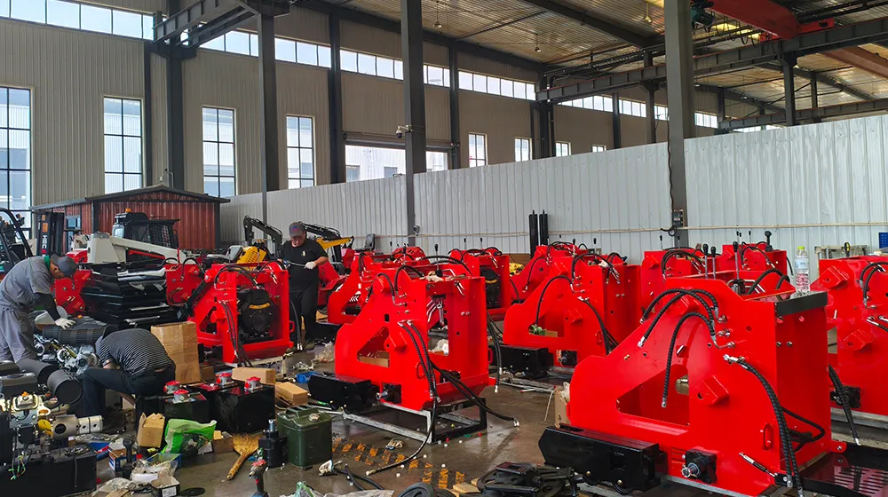 Komponen skid steer loader merah sedang dirakit di bengkel pabrik.