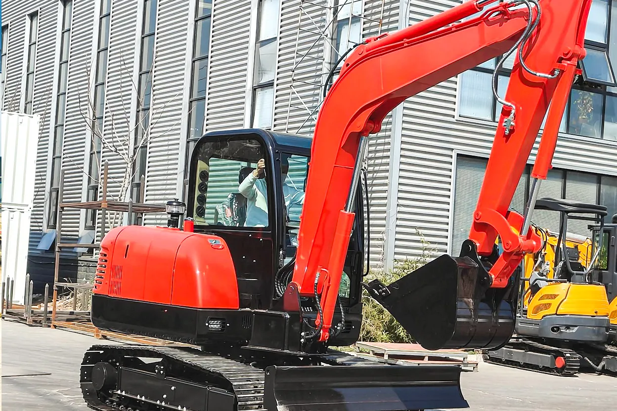 Red HT60 mini excavator parked outside industrial building with bucket on ground