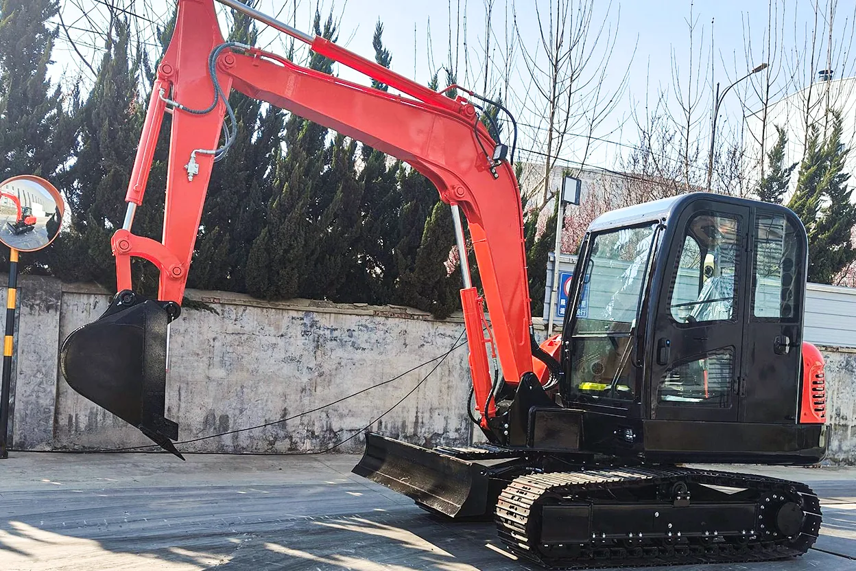 Red HT60 mini excavator parked outside industrial building with bucket on ground