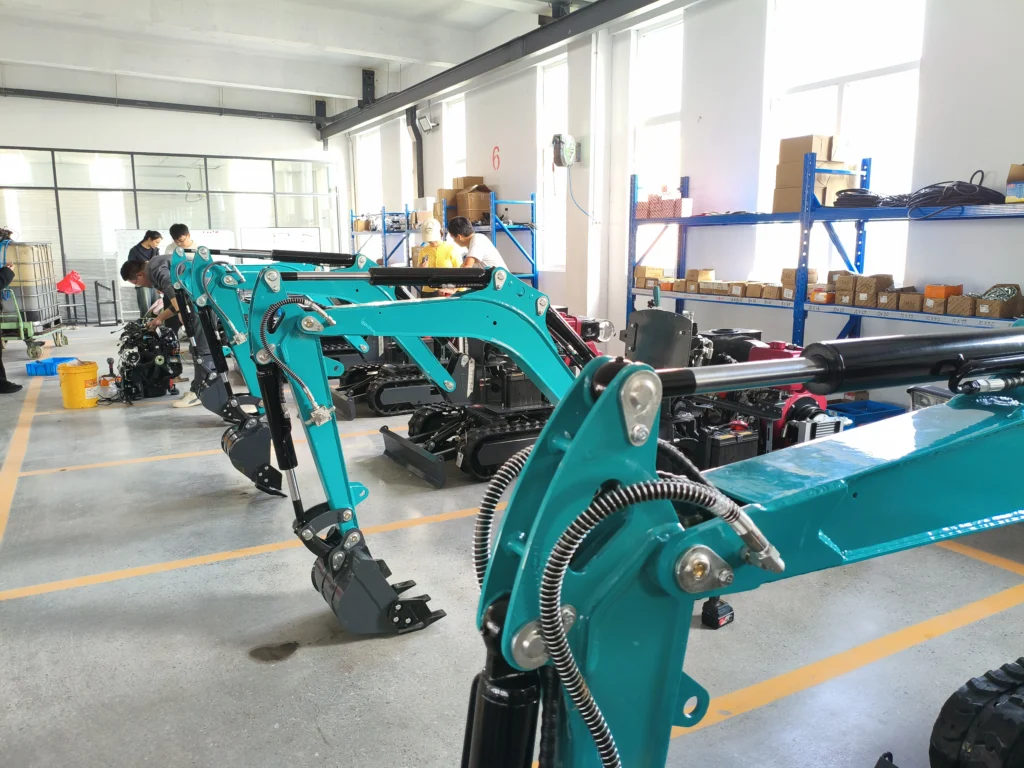 Deretan ekskavator mini berwarna hijau sedang dirakit di bengkel