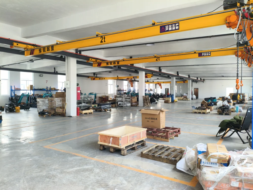 Lantai pabrik dengan derek overhead, palet, dan peralatan pengemasan