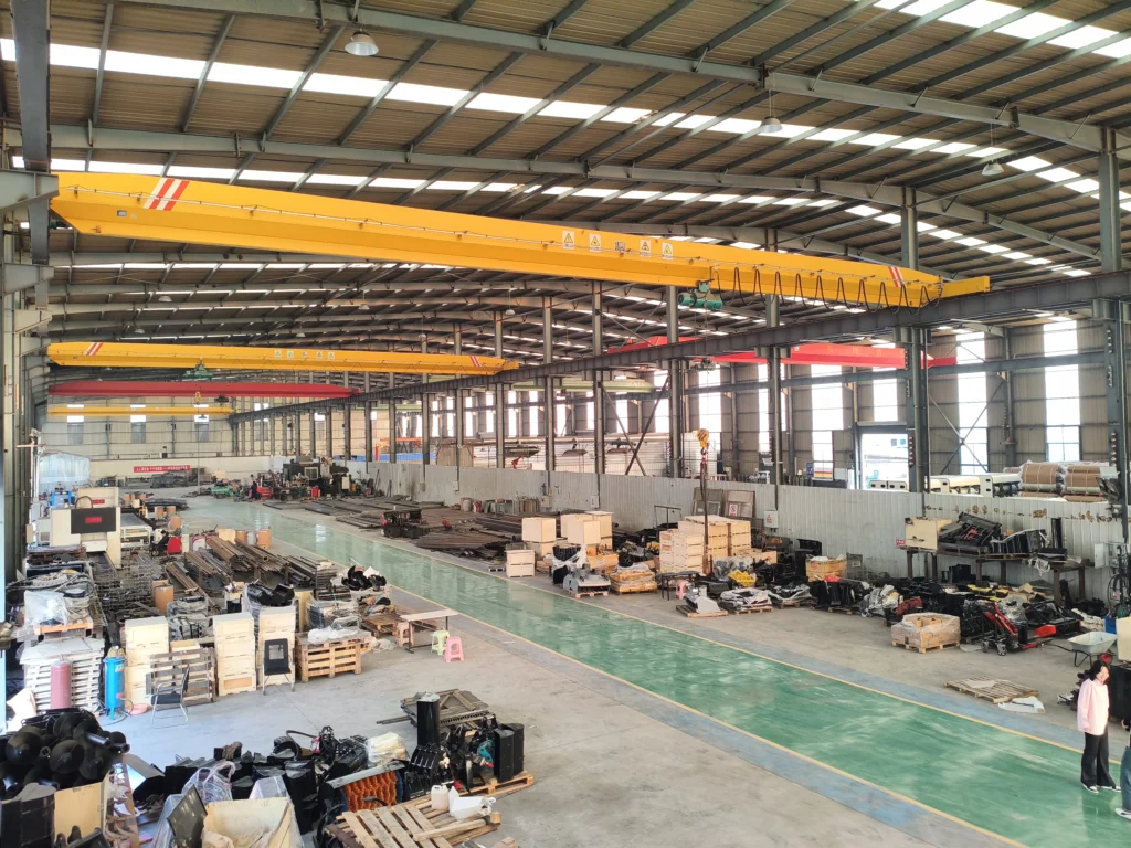 Aula pabrik yang besar dengan beberapa jalur produksi dan suku cadang ekskavator