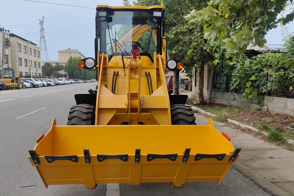 Front view of TCB 15-26 backhoe loader with wide loader bucket facing the camera